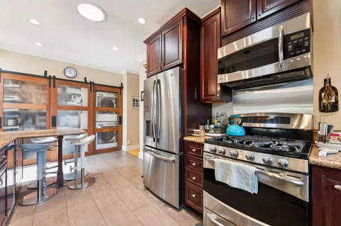 a open kitchen with granite countertop a stove and a wooden floor