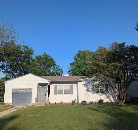 a front view of house with yard and trees in the background