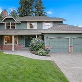 a front view of a house with a garden and garage