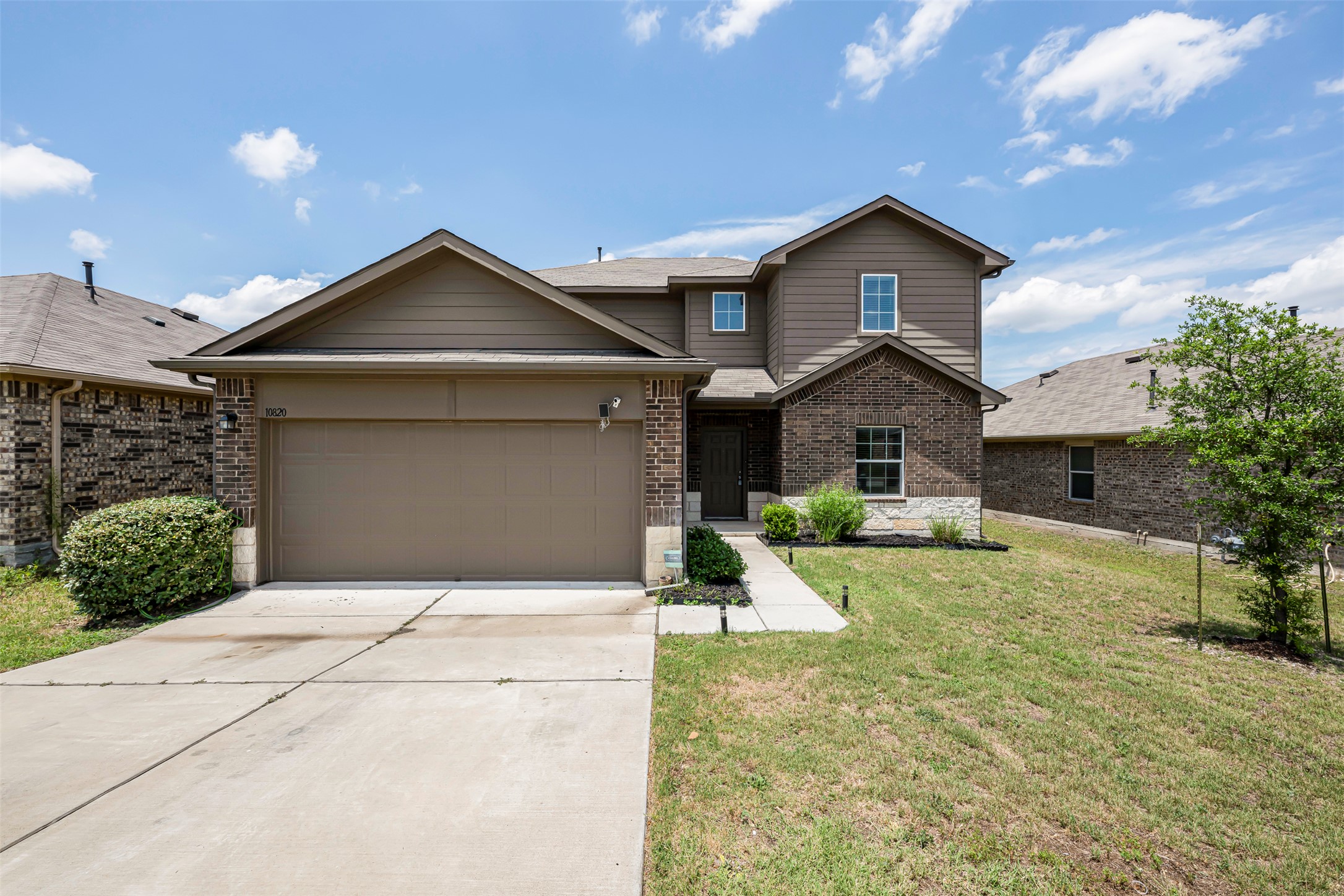 10820 Gonzales Ranger Pass Austin, TX 78754 - Photo 1 of 1 Traditional home with brick siding, driveway, a garage, and a front yard