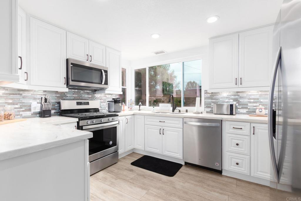 9325 Westhill Road Lakeside, CA 92040 - Photo 1 of 1 a kitchen with stainless steel appliances a stove sink microwave and cabinets