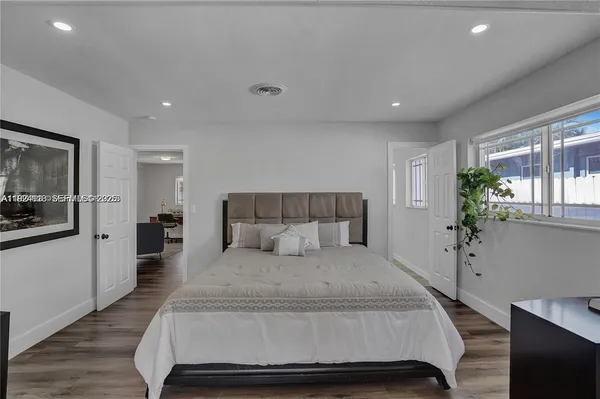 a bedroom with a large bed and potted plant
