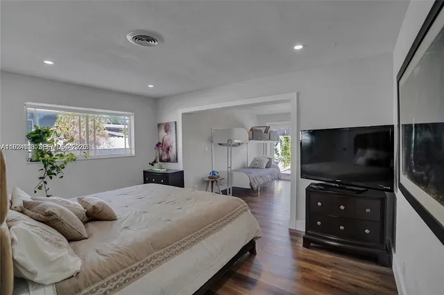 a bedroom with a bed and a flat screen tv