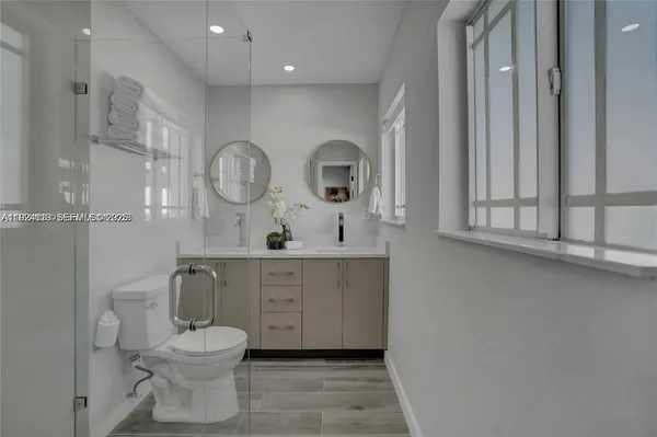 a spacious bathroom with a toilet a sink and a mirror