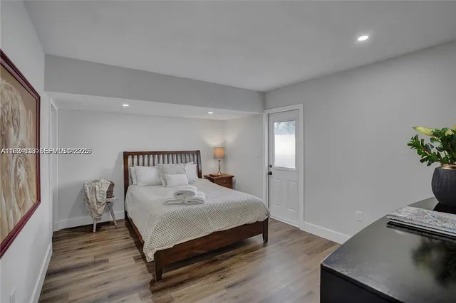 a bedroom with a bed and a potted plant on table