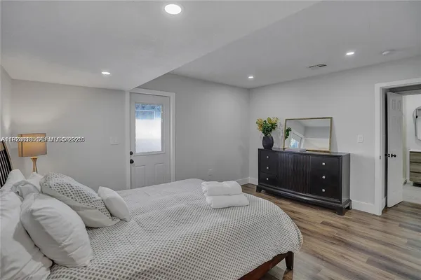 a bedroom with a bed and a lamp on dresser
