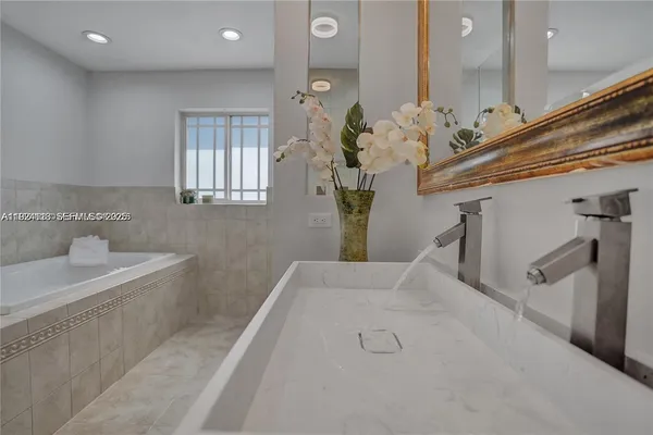 a bathroom with a sink a mirror and a bathtub