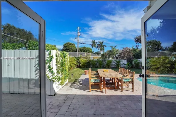 a view of a patio with a table and chairs and potted plants