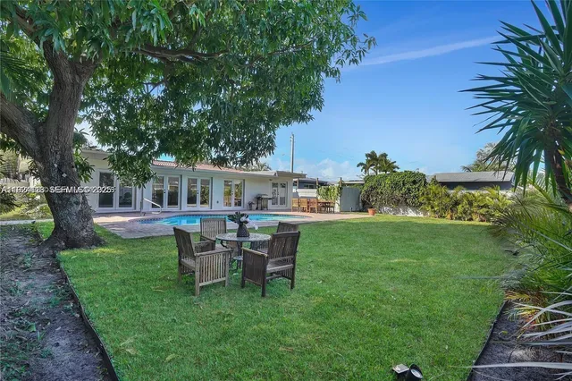 a view of a house with backyard sitting area and garden