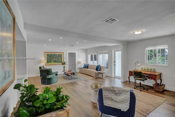 a living room with furniture and a wooden floor