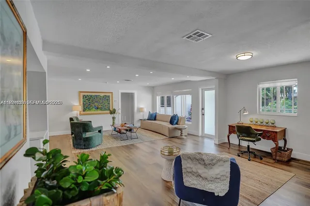 a living room with furniture and a wooden floor