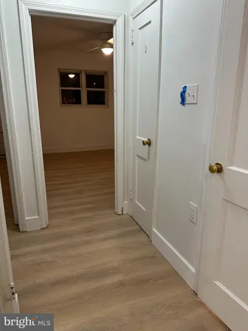 a view of a hallway with wooden floor and door