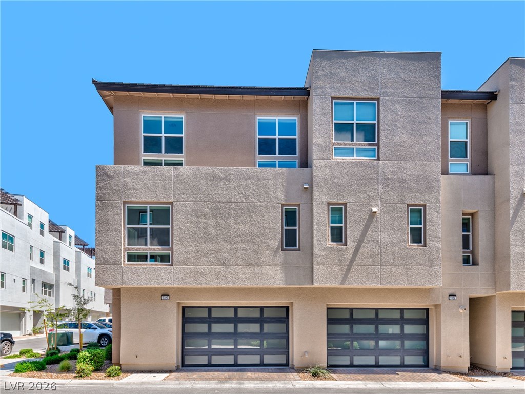 3327 Esker Rdg Avenue Henderson, NV 89044 - Photo 24 of 24 Modern multi-level townhome featuring sleek garage doors and abundant windows.
