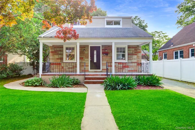 a front view of a house with a garden and plants
