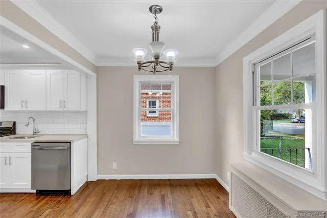 a view of a kitchen with wooden floor and a window