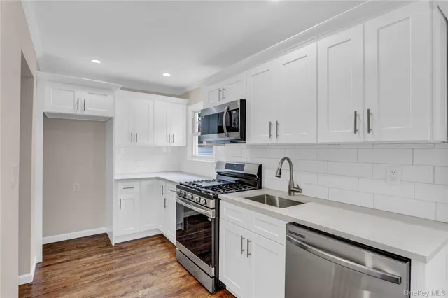 a kitchen with granite countertop a sink a stove and cabinets