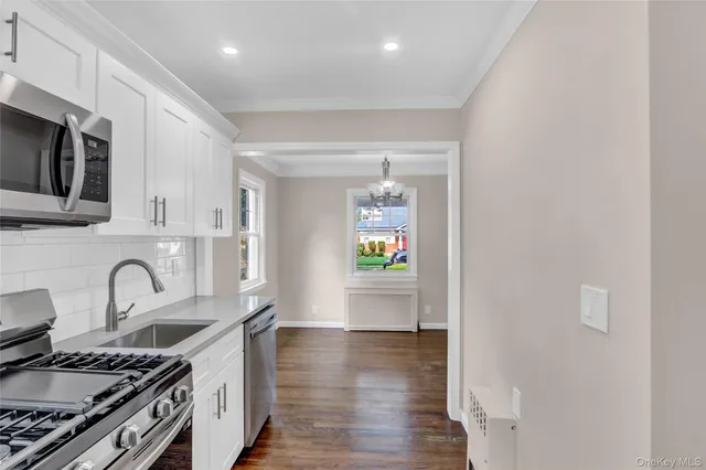 a kitchen with stainless steel appliances a stove a sink and a microwave
