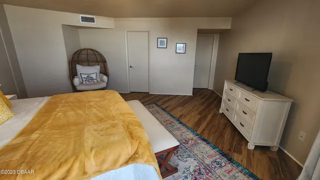 a bedroom with a bed and a flat tv screen on the dresser