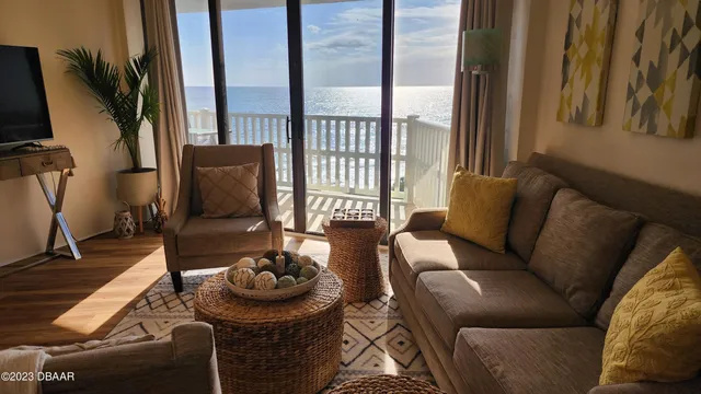 a living room with furniture a rug and a floor to ceiling window