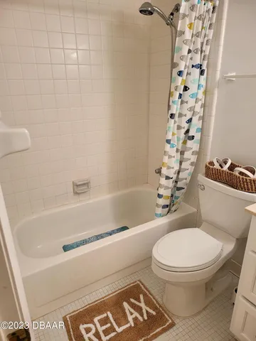 a white toilet sitting next to a bath tub
