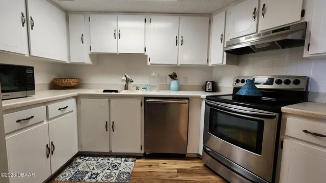 a kitchen with stainless steel appliances a stove a sink and cabinets