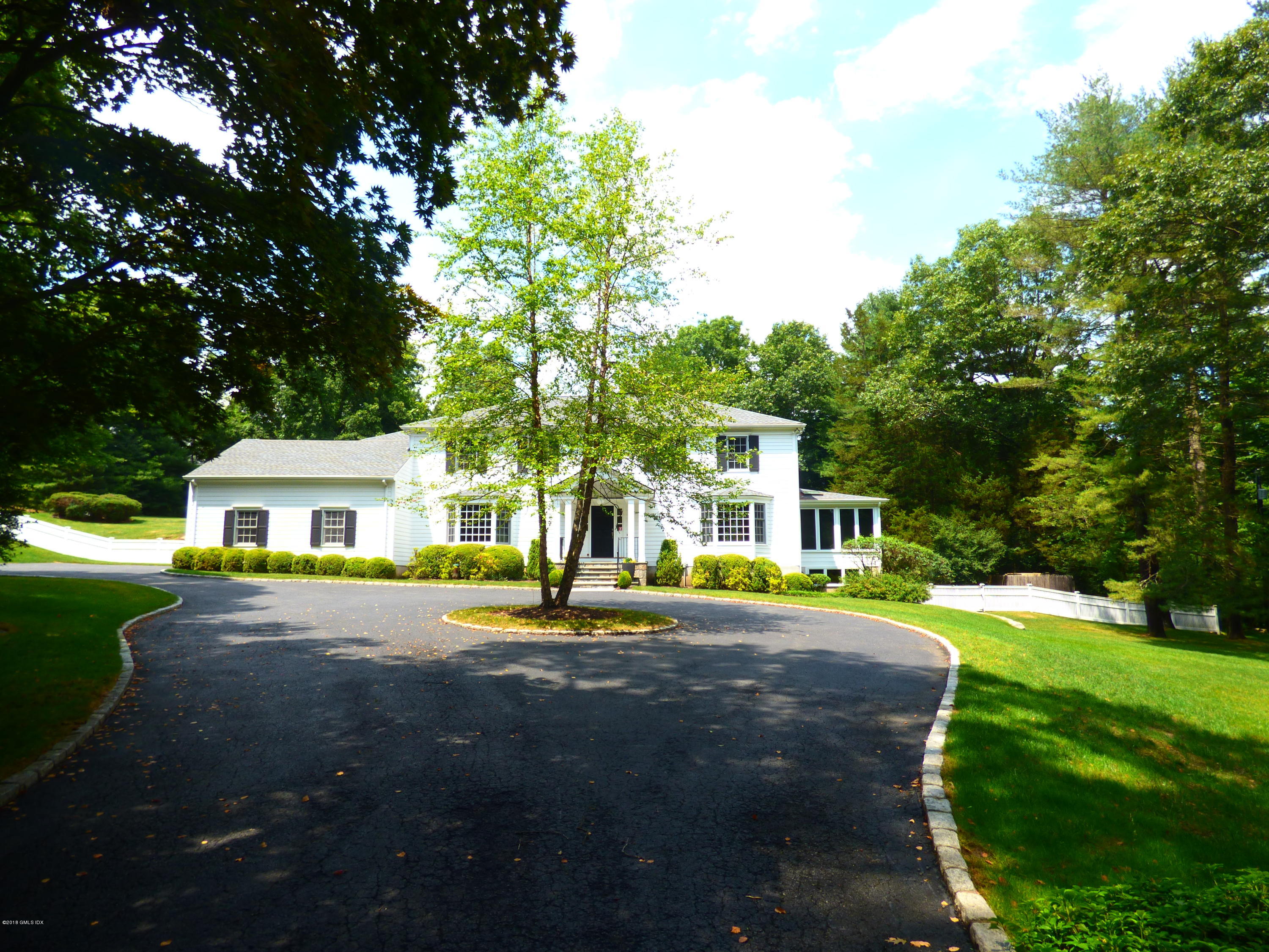 111 Dingletown Road Greenwich, CT 06830 - Photo 2 of 44 a front view of a house with a yard and trees