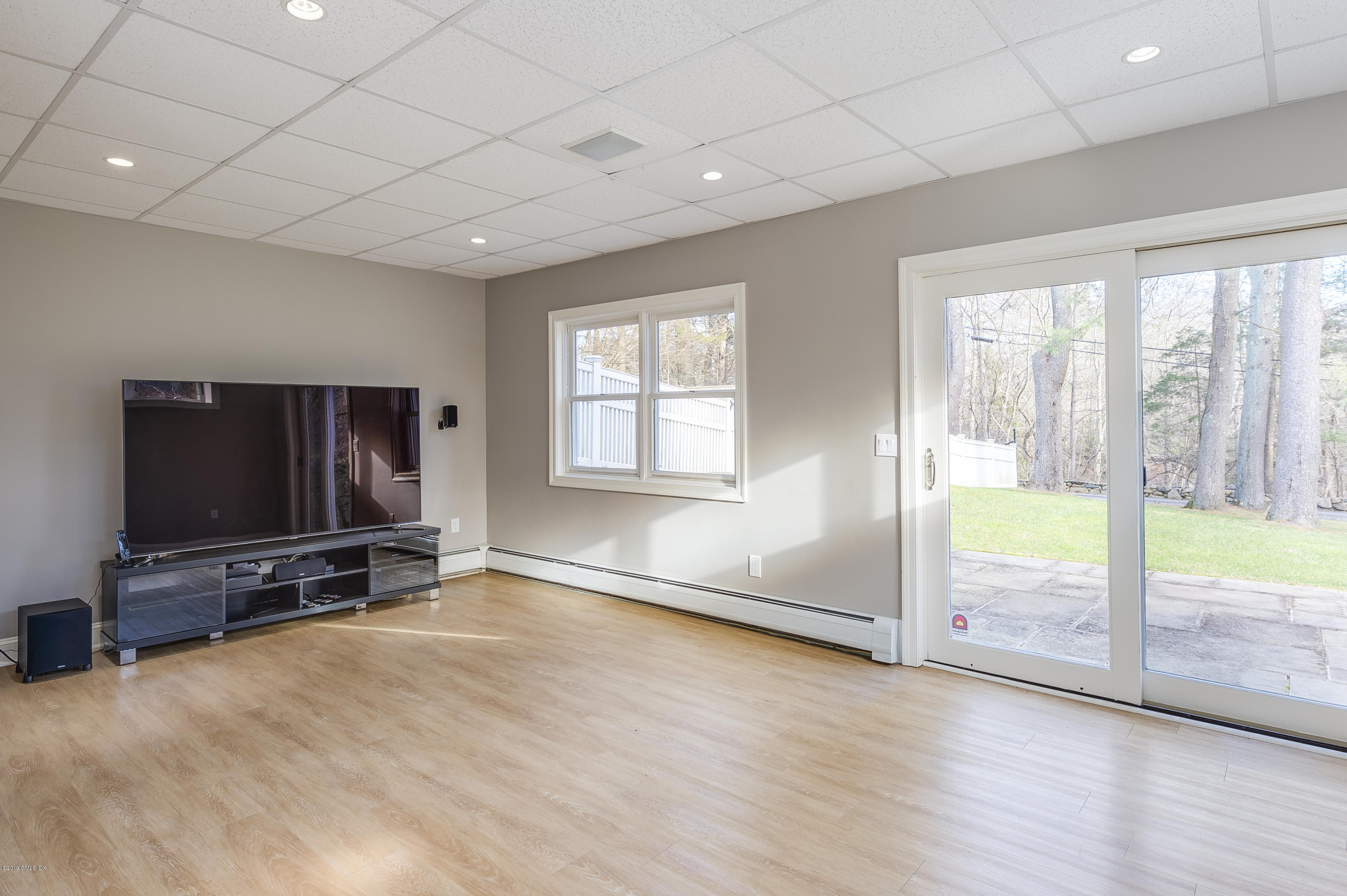 111 Dingletown Road Greenwich, CT 06830 - Photo 35 of 44 an empty room with floor to ceiling window and flat screen tv