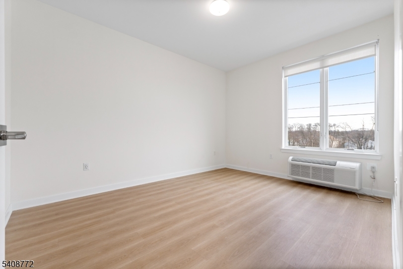 321 East 3rd Street, Unit 320 Plainfield, NJ 07060 - Photo 27 of 43 an empty room with wooden floor and windows