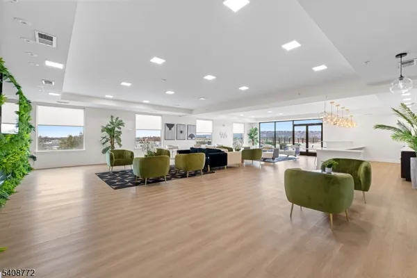 a living room with furniture floor to ceiling window and wooden floor