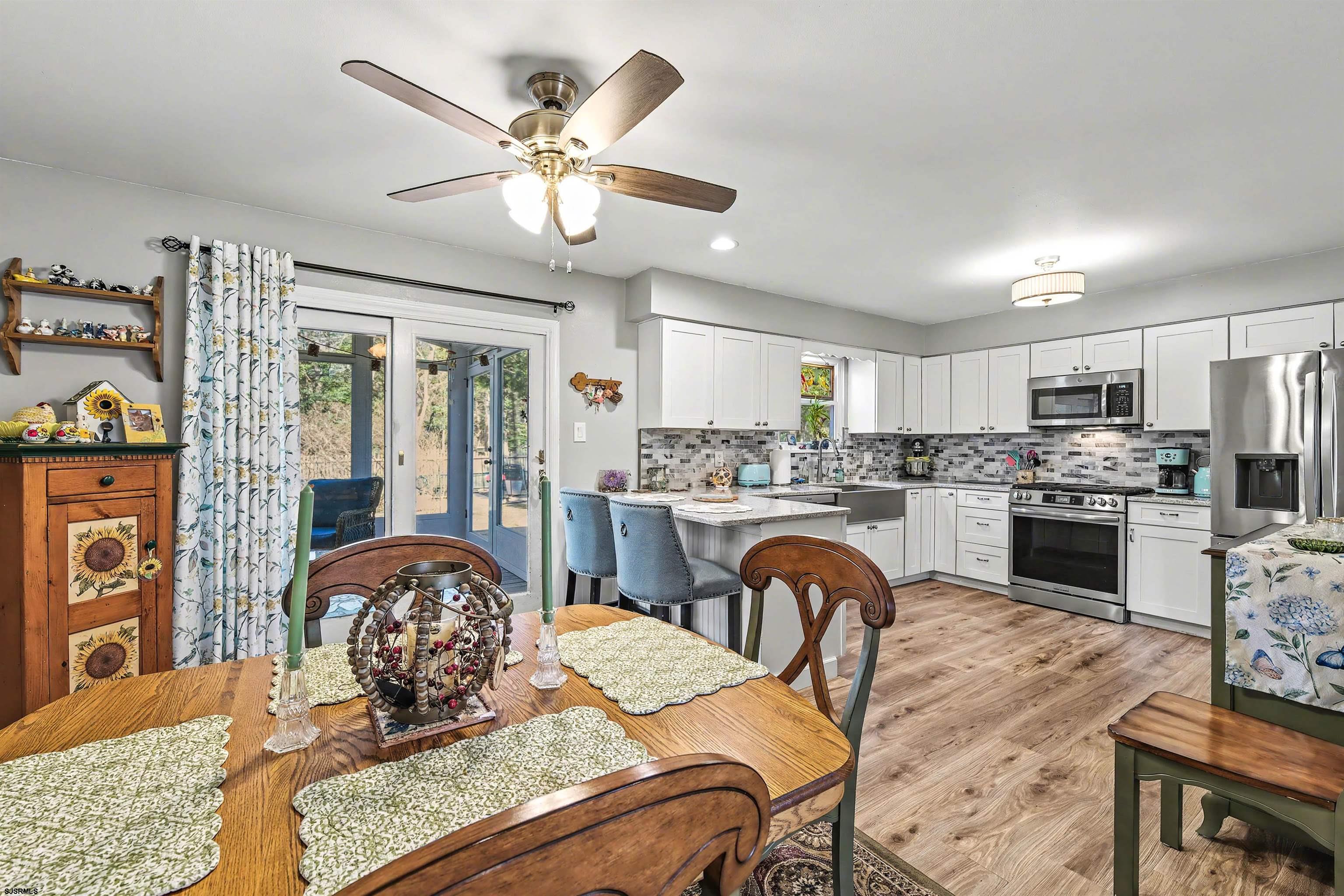 655 Weilers Lane Absecon, NJ 08201 - Photo 6 of 31 a kitchen with a refrigerator a stove a sink a dining table and chairs with wooden floor