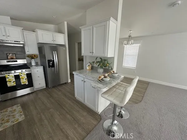 a kitchen with stainless steel appliances granite countertop a refrigerator a stove a sink and a stove