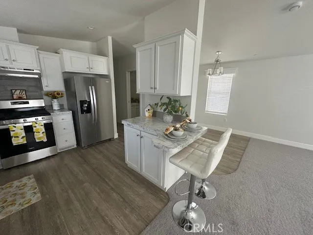 a kitchen with stainless steel appliances granite countertop a refrigerator a stove a sink and a stove