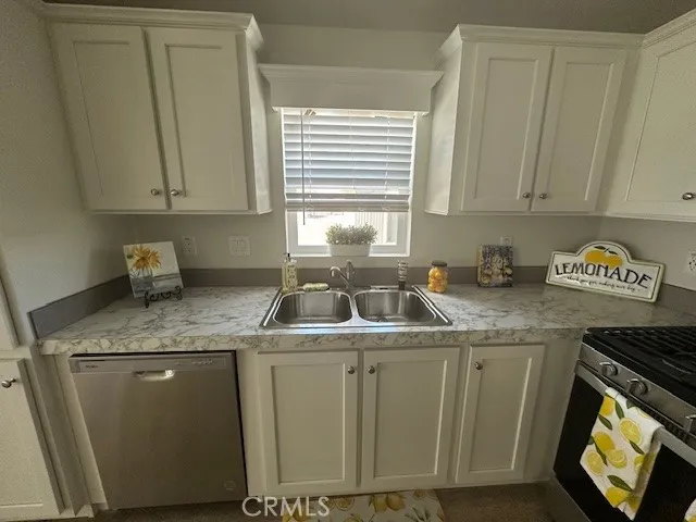 a kitchen with stainless steel appliances granite countertop a sink stove and cabinets