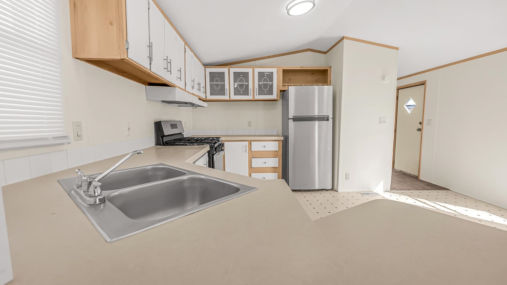 534 Normandy Way Grand Junction, CO 81501 - Photo 13 of 32 a kitchen with stainless steel appliances granite countertop a sink and a refrigerator
