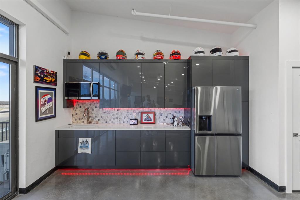400 Fast Lane, Unit 9 Anna, TX 75409 - Photo 18 of 37 Kitchen featuring stainless steel refrigerator with ice dispenser, modern cabinets, finished concrete flooring, decorative backsplash, and light stone counters