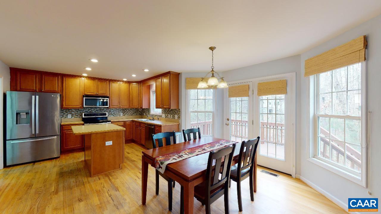 9 Tanglewood Road Palmyra, VA 22963 - Photo 6 of 34 a kitchen with stainless steel appliances kitchen island granite countertop a refrigerator a stove a dining table and chairs with wooden floor