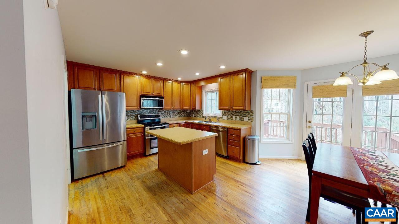 9 Tanglewood Road Palmyra, VA 22963 - Photo 8 of 34 a kitchen with stainless steel appliances granite countertop a refrigerator a stove top oven a sink dishwasher a dining table and chairs with wooden floor