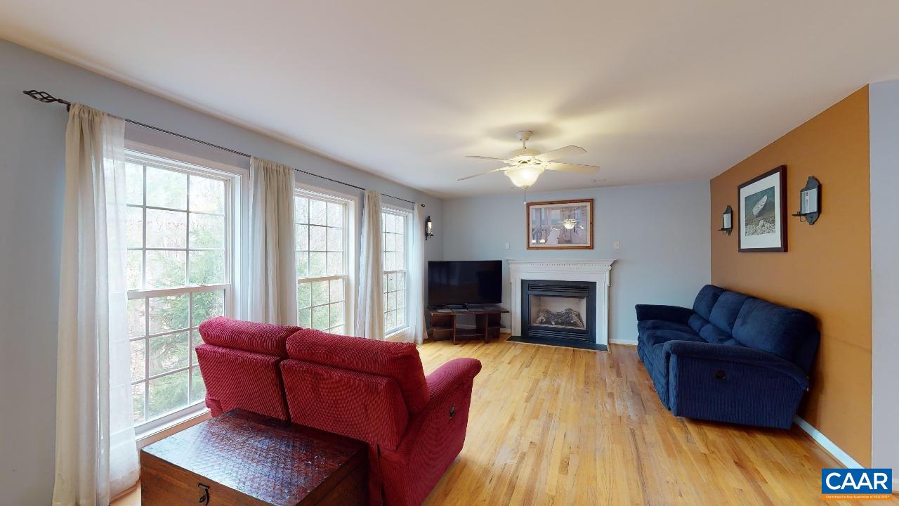 9 Tanglewood Road Palmyra, VA 22963 - Photo 9 of 34 a living room with furniture a fireplace and a flat screen tv