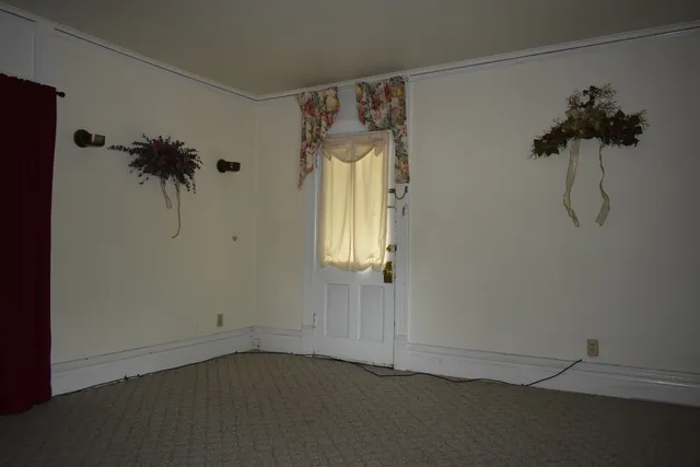 a view of a white house with a big yard and large trees