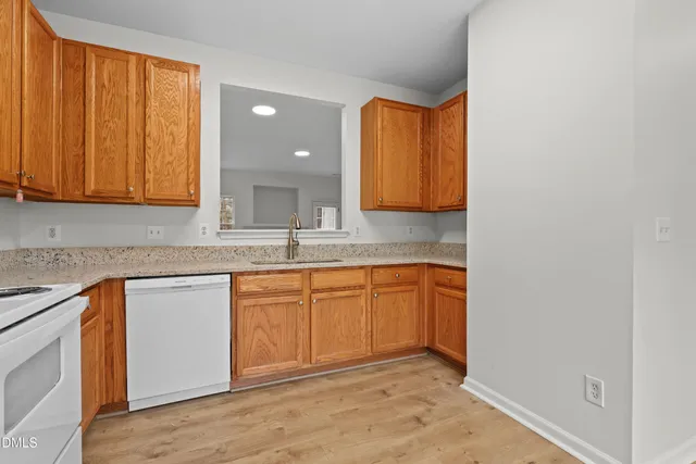 a kitchen with granite countertop cabinets sink and wooden floor