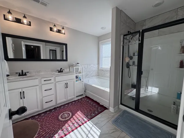 a spacious bathroom with a shower a sink and a mirror