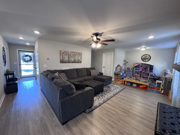 a living room with furniture and a wooden floor