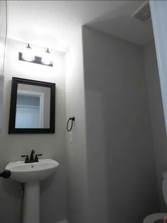 a bathroom with a sink toilet and mirror