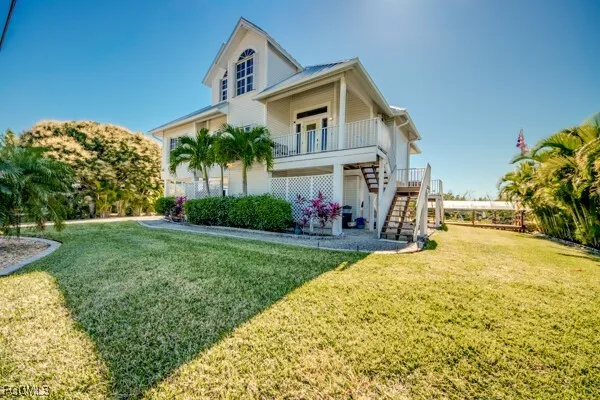 a view of a house with a yard and potted plants
