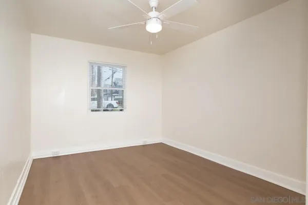 an empty room with a fan & a ceiling fan