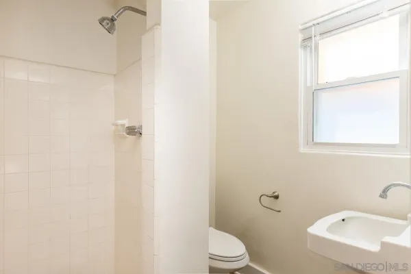 a white toilet sitting next to a bathroom sink