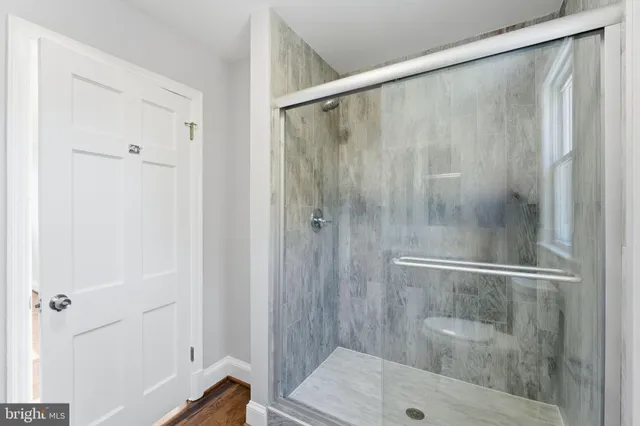 a bathroom with a granite countertop sink toilet mirror and shower