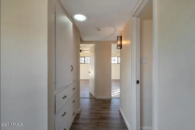a view of a hallway with wooden floor and closet area
