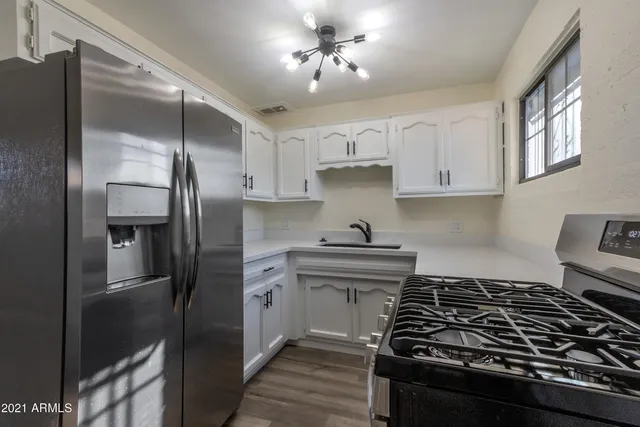 a kitchen with a stove a refrigerator and cabinets