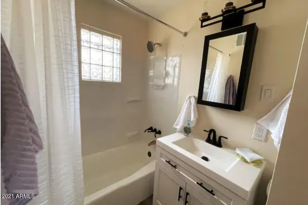 a bathroom with a bathtub sink and mirror